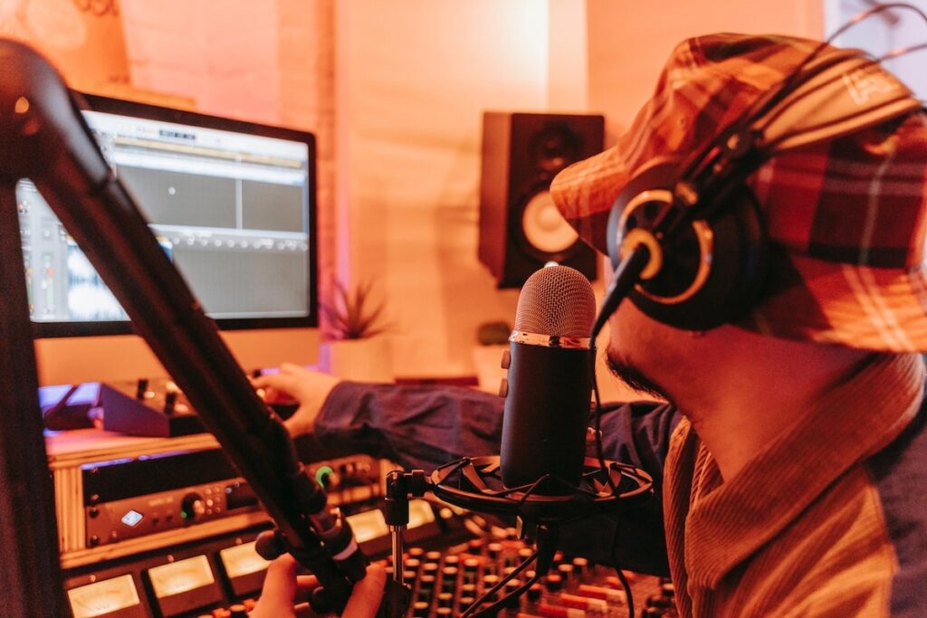 musician recording with guitar, microphone, headphones, interface